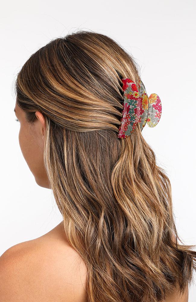 Pink Floral Claw Hair Clip on woman with medium length brown hair pulled back behind head