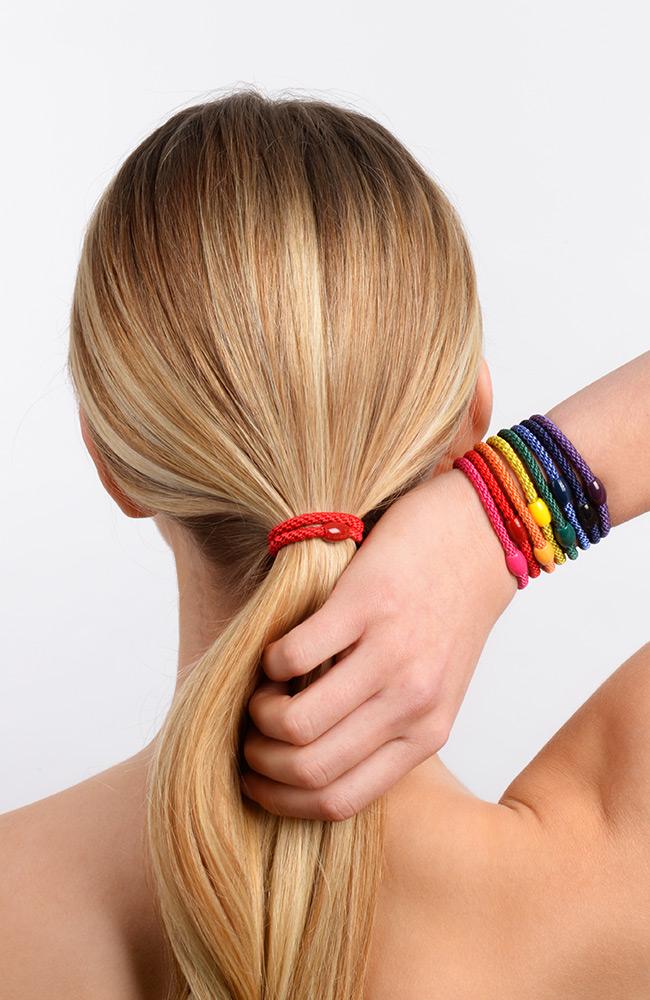 Elastic Hair Ties, Narrow Grab & Go Ponytail Holder 12 Pack, Pride pictured on model (red, coral, orange, yellow, lime green, forrest green, navy blue, aqua blue, magenta, pink, lavender, violet purple)